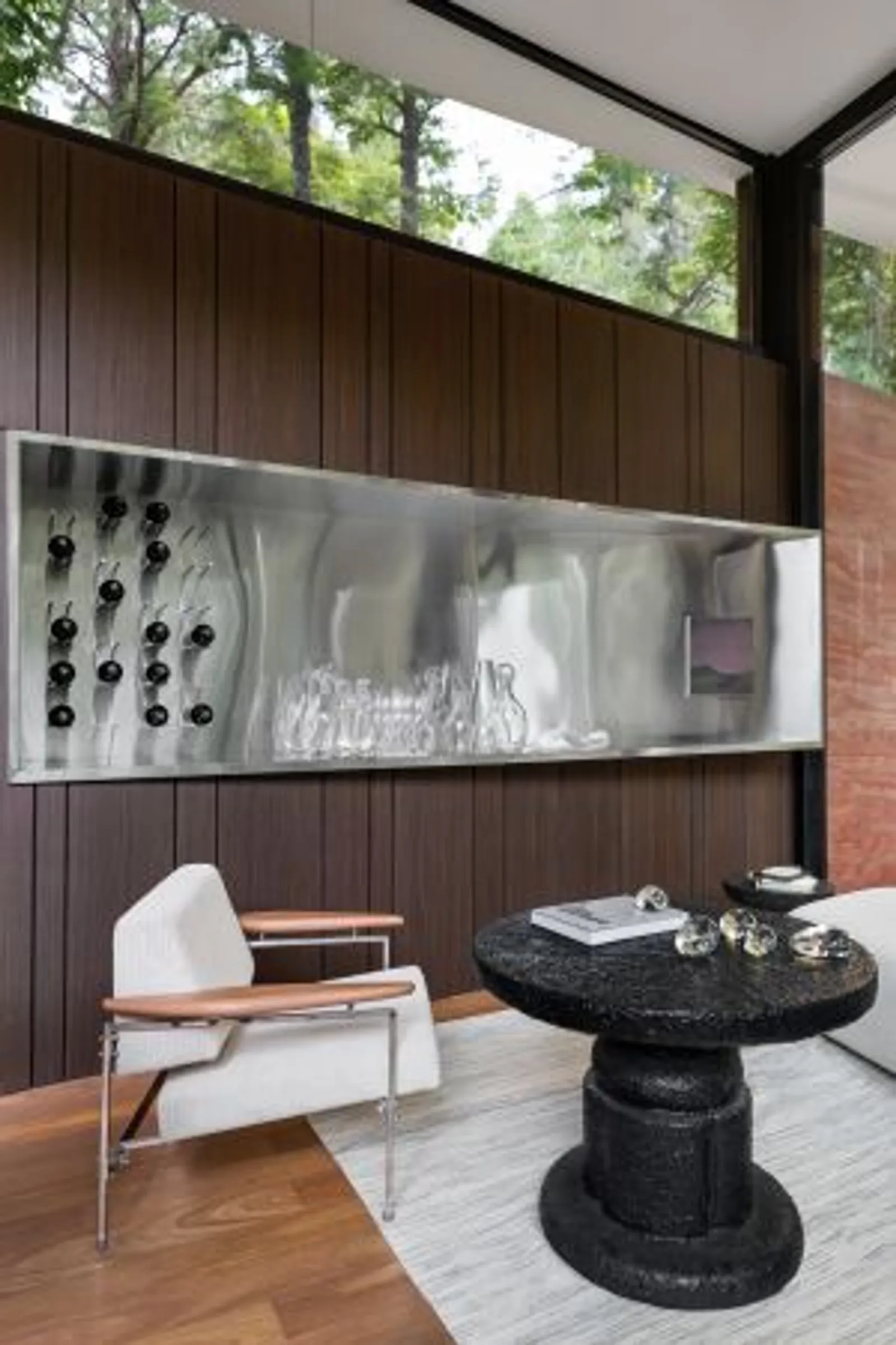Vista do living da Casa Limiar R, com mobiliário de designers brasileiros e peças autorais de Felipe Rossi.