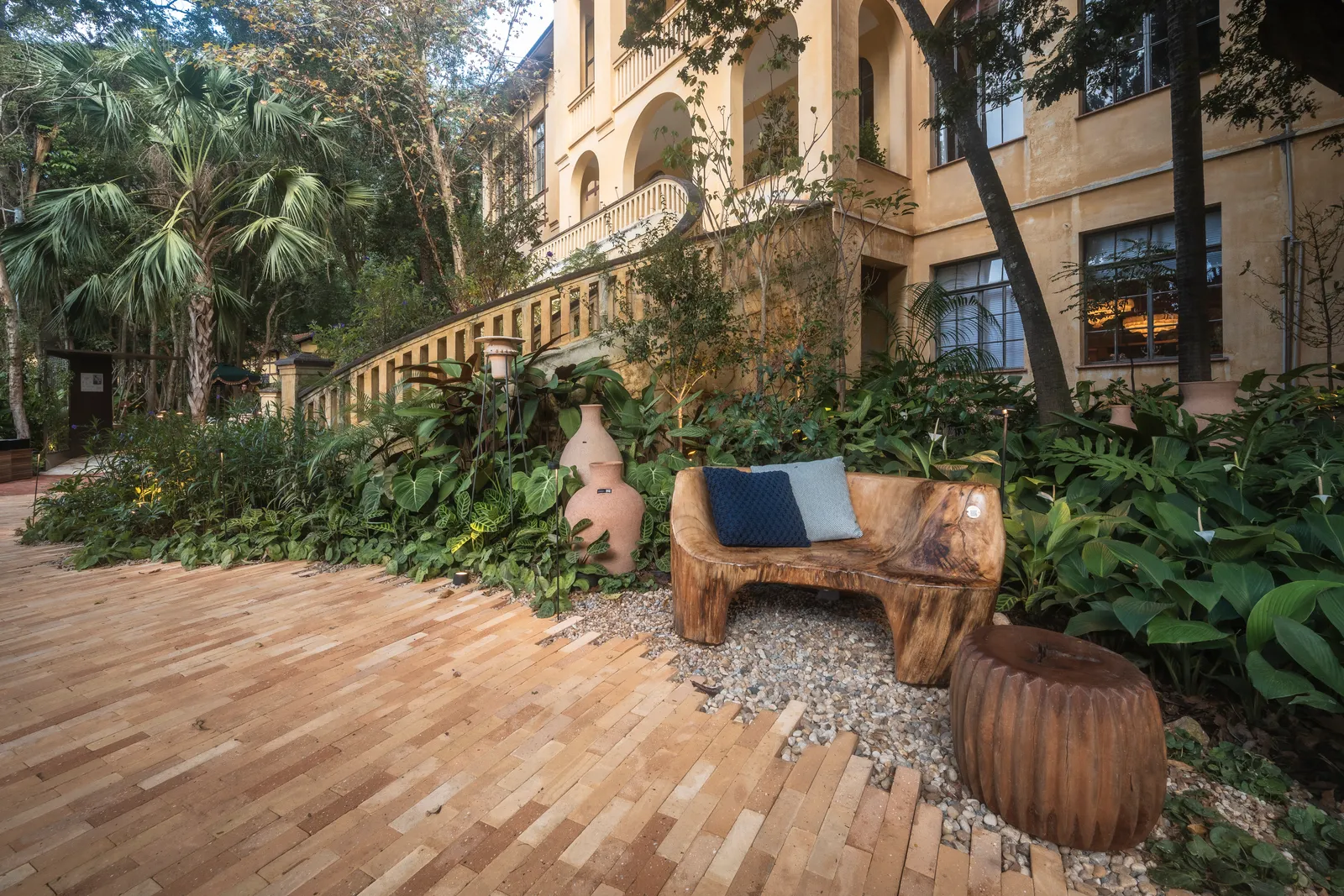 Projeto: Maria Fernanda Marques, Da terra ao solo | Detalhe do jardim 'Da Terra ao Solo', evidenciando a diversidade de plantas e a integração com elementos artísticos e artesanais.