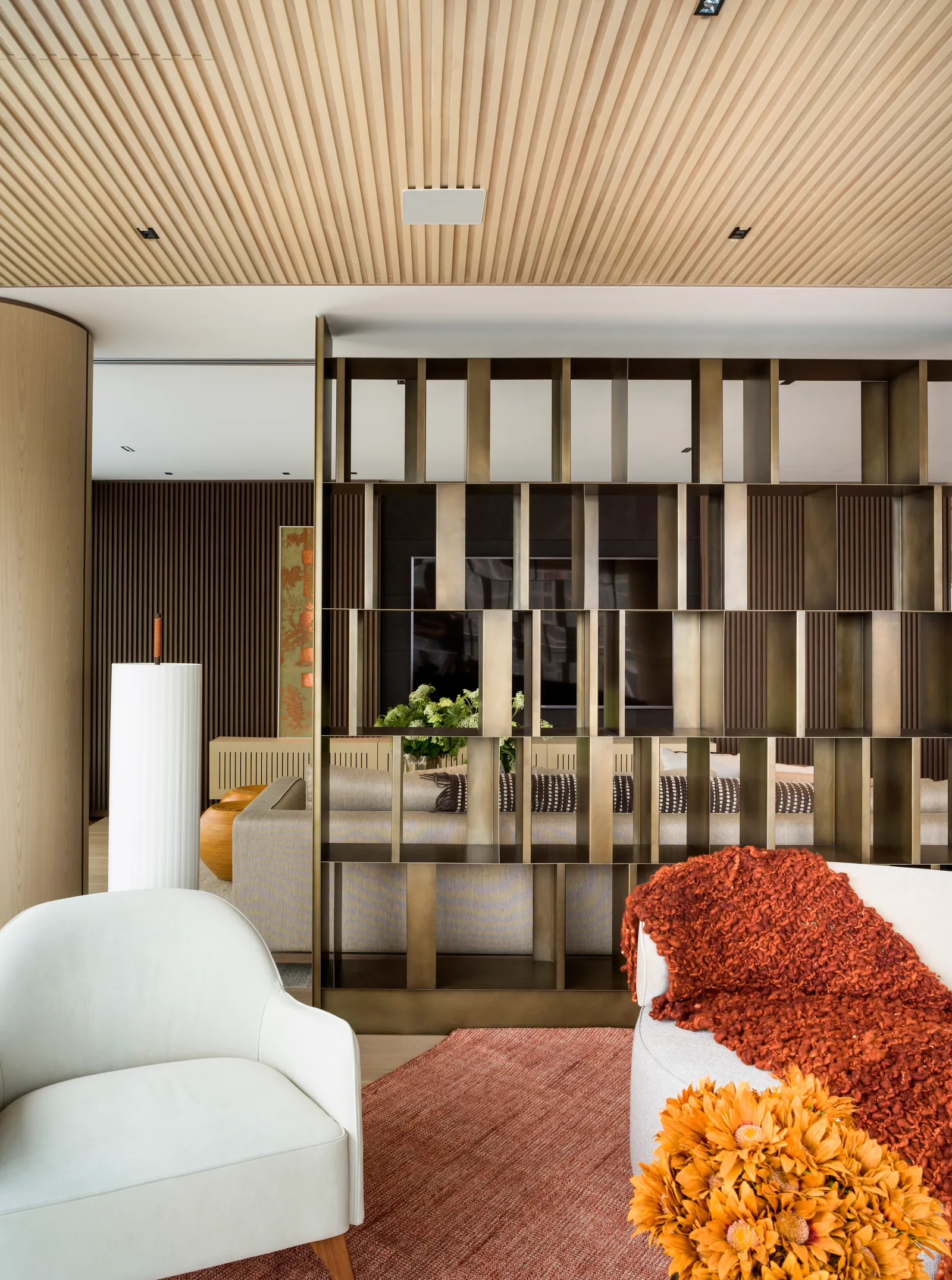 Projeto: Denise Barretto | Para delimitar o ambiente de estar em primeiro plano e a sala de TV ao fundo, a arquiteta Denise Barretto apostou no mix entre serralheria e marcenaria: a divisória metálica e o teto ripado em MDF demarcam os dois ambientes