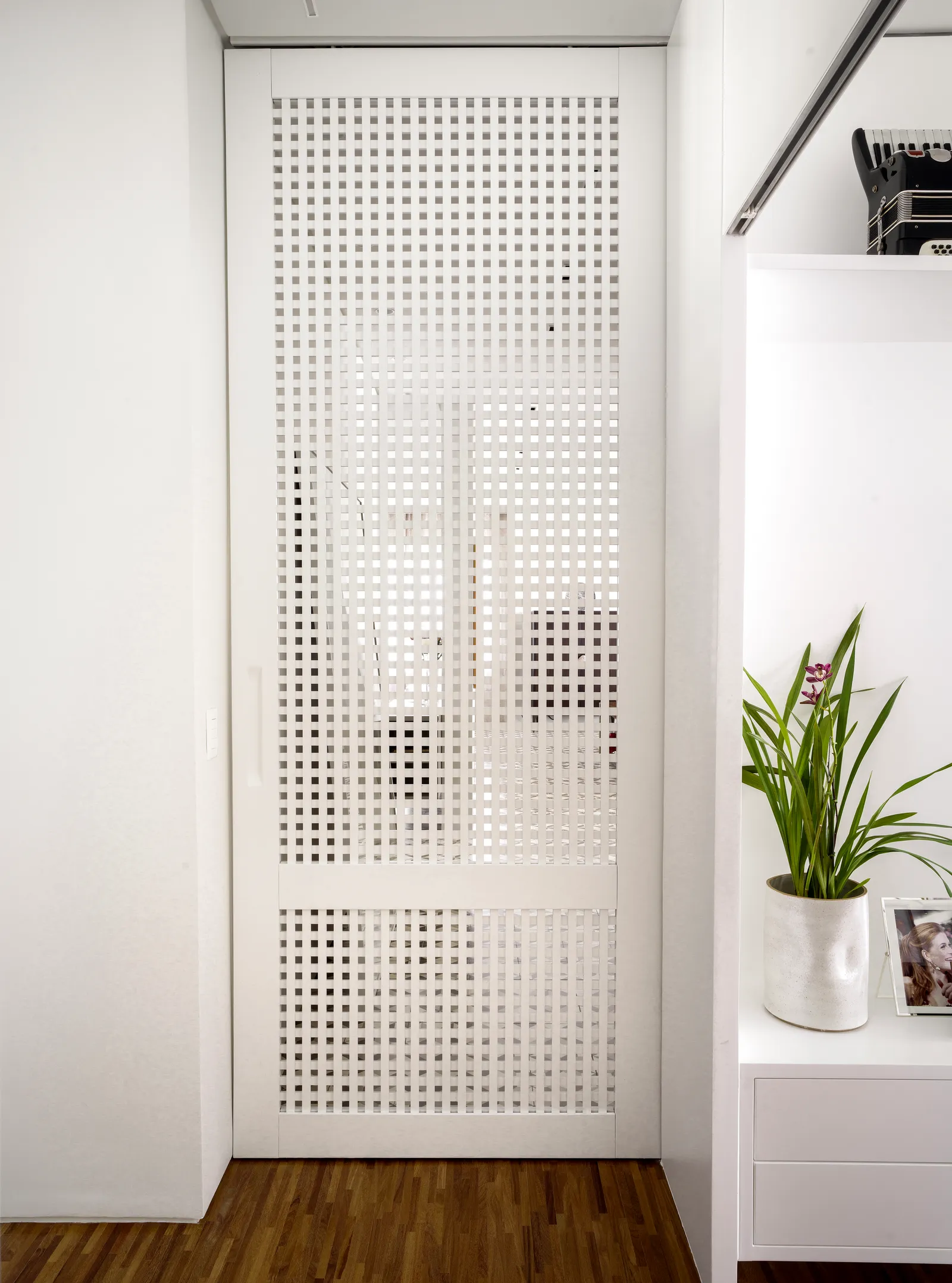 Projeto: Denise Barretto | A sala de TV deste apartamento executado pela arquiteta Denise Barretto é acessada através de uma porta em muxarabi. O espaço, ainda que mais reservado, ganha com a iluminação natural da área social, incorporando uma divisória leve e integrada ao conjunto