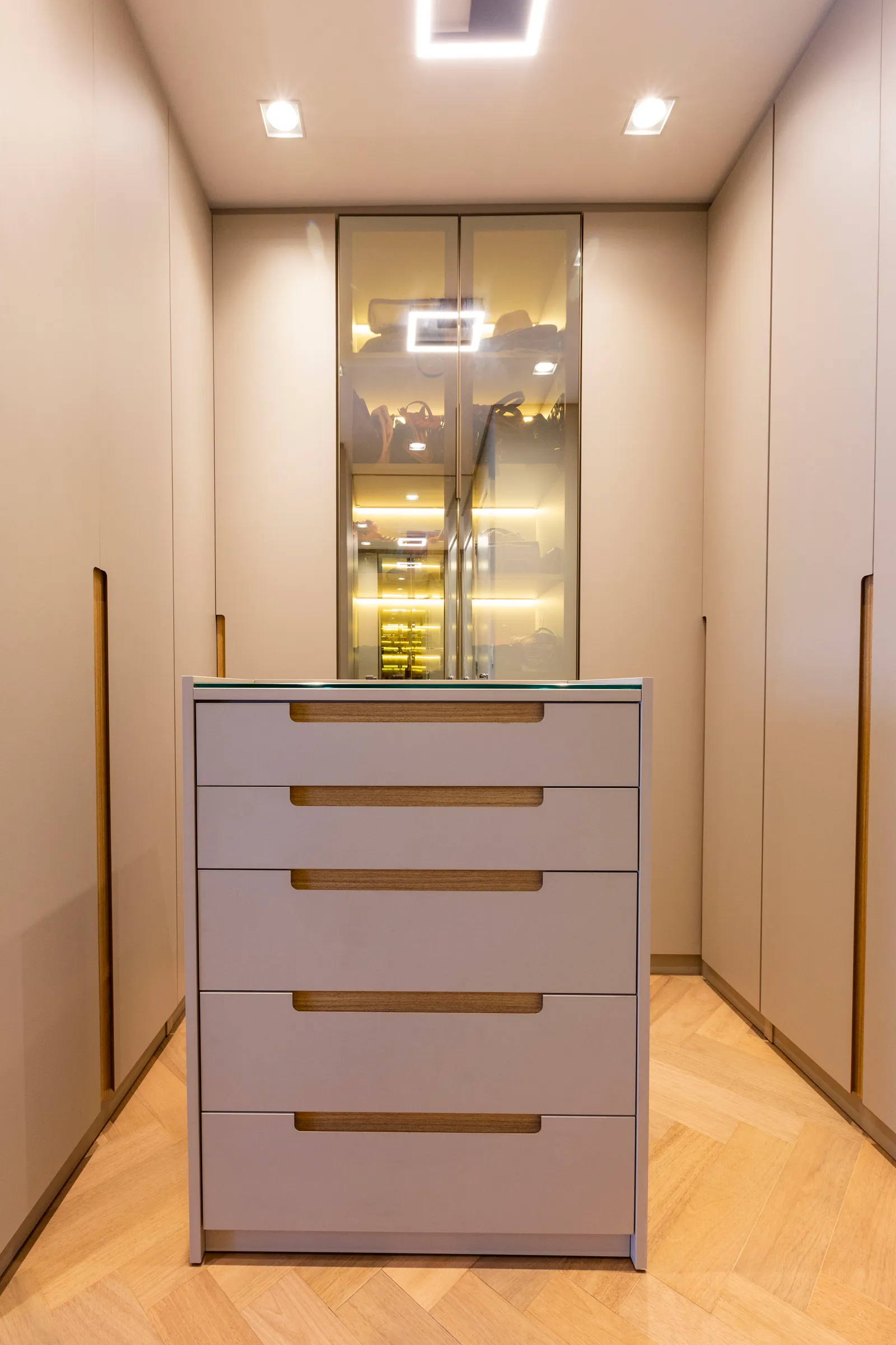 Para este closet walk-in, a arquiteta Daniela Funari trouxe apenas uma abertura central e o tampo da cômoda com o vidro reflecta, enquanto todo o restante do setor foi executado em marcenaria. “A ideia foi apresentá-lo como um ponto focal”, diz | FOTOS: Mariana Camargo