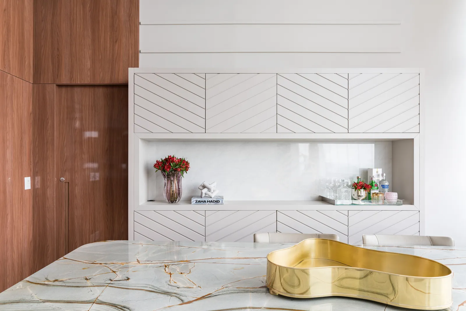 Nesta mesa de jantar, apenas a bandeja dourada, eleita pela arquiteta Ana Rozenblit, foi suficiente para adornar a mesa de lâmina sintetizada que emula os veios do mármore | Projeto: Spaço Interior