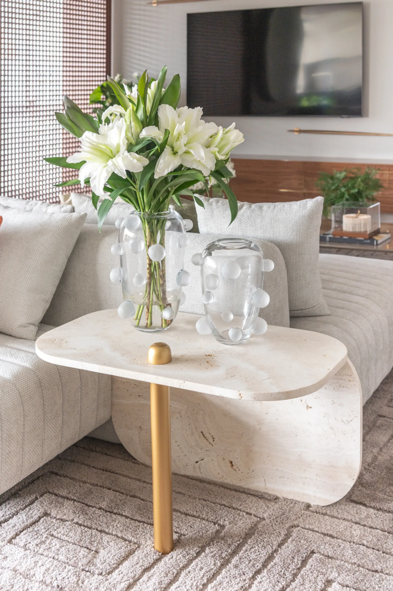 Mesas de apoio, normalmente associadas à função de suporte, tem o design valorizado quando recebem o acabamento dourado na estrutura. Nas propostas da arquiteta Ana Rozenblit, o metal evidencia o design das peças | Projeto: Spaço Interior