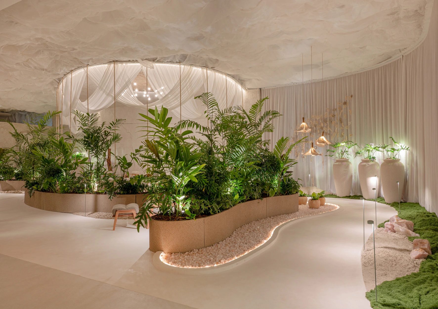 Vista do Jardim Ecos do Éden by Hantei na CASACOR/SC, com destaque para a iluminação que realça as plantas e elementos d