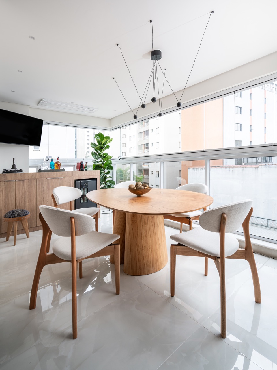 Projeto: Lima Vari Arquitetos | Vista da sala de jantar com mesa redonda e cadeiras modernas, integrada ao ambiente social.