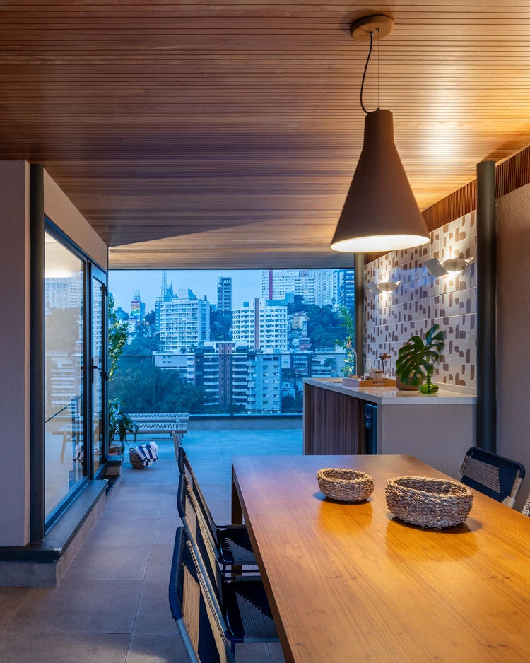 Projeto: MDH.Arq — Fernando Milan - Vista noturna do pavilhão, destacando a iluminação e a atmosfera de refúgio urbano.