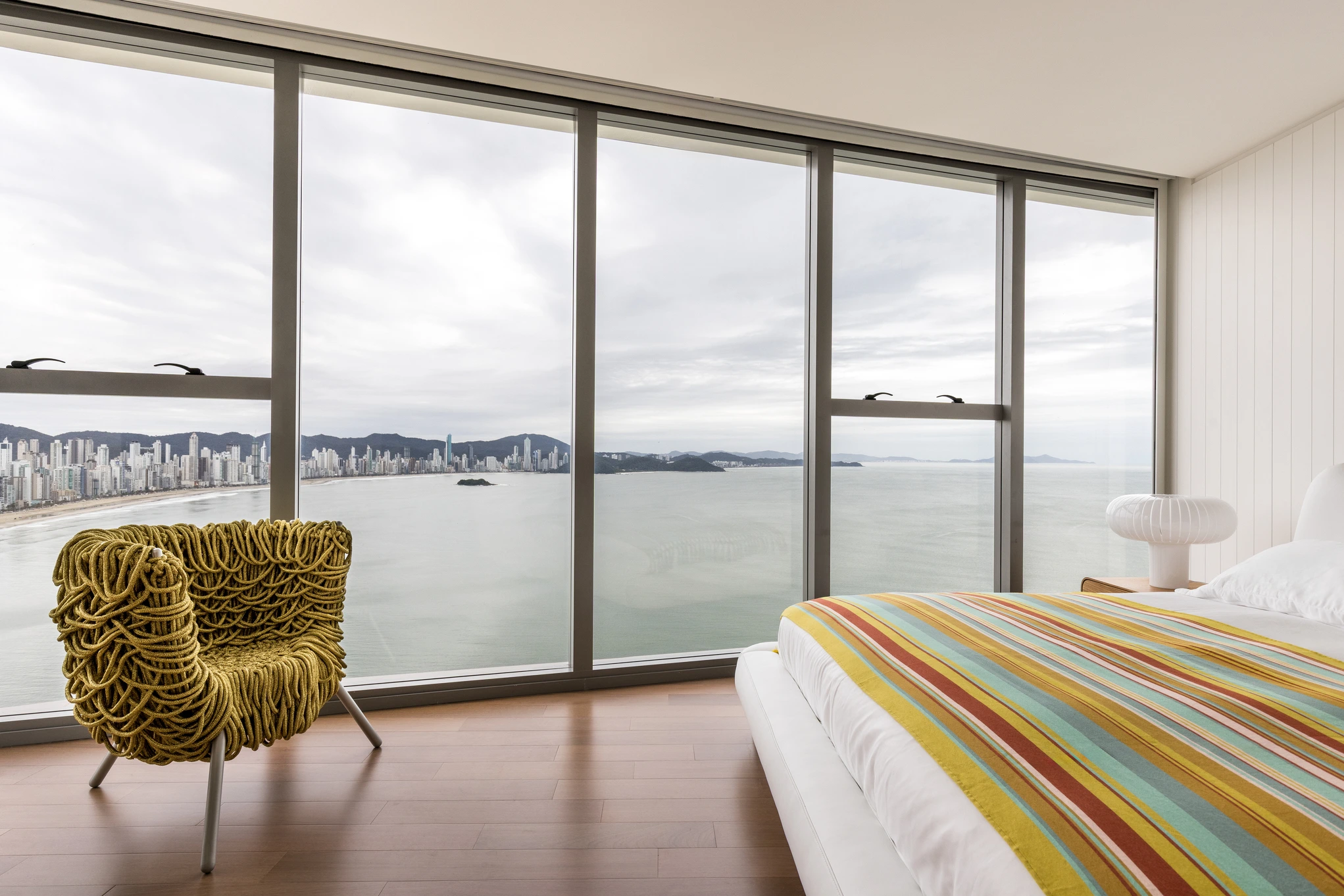 Projeto: Paola Granzotto |Vista panorâmica do apartamento, destacando a integração dos ambientes e a vista para o mar.