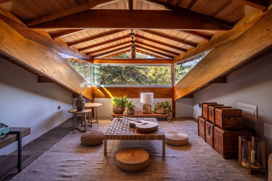 Projeto: Paulo Tripoloni | Nesta residência projetada pelo arquiteto Paulo Tripoloni, o sótão ganhou um novo sentido para a família. Ao invés de ser mais um espaço de armazenamento, tornou-se um ambiente que equilibra recolhimento e convivência, com luz natural abundante e uma vista que se abre como cenário.